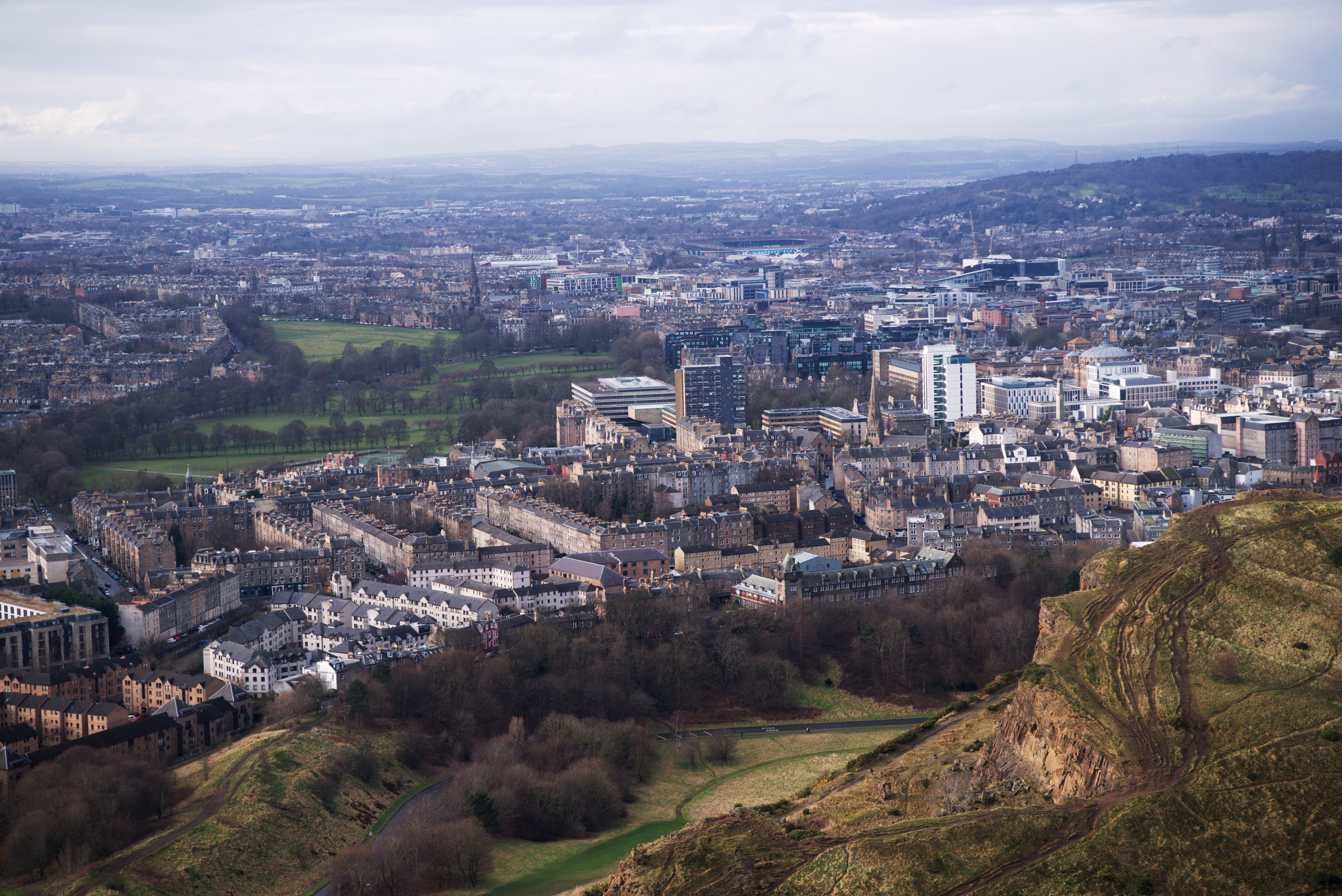 A breathtaking aerial view of Edinburgh cityscape from Arthur's Seat, showcasing vibrant urban architecture and natural landscapes.