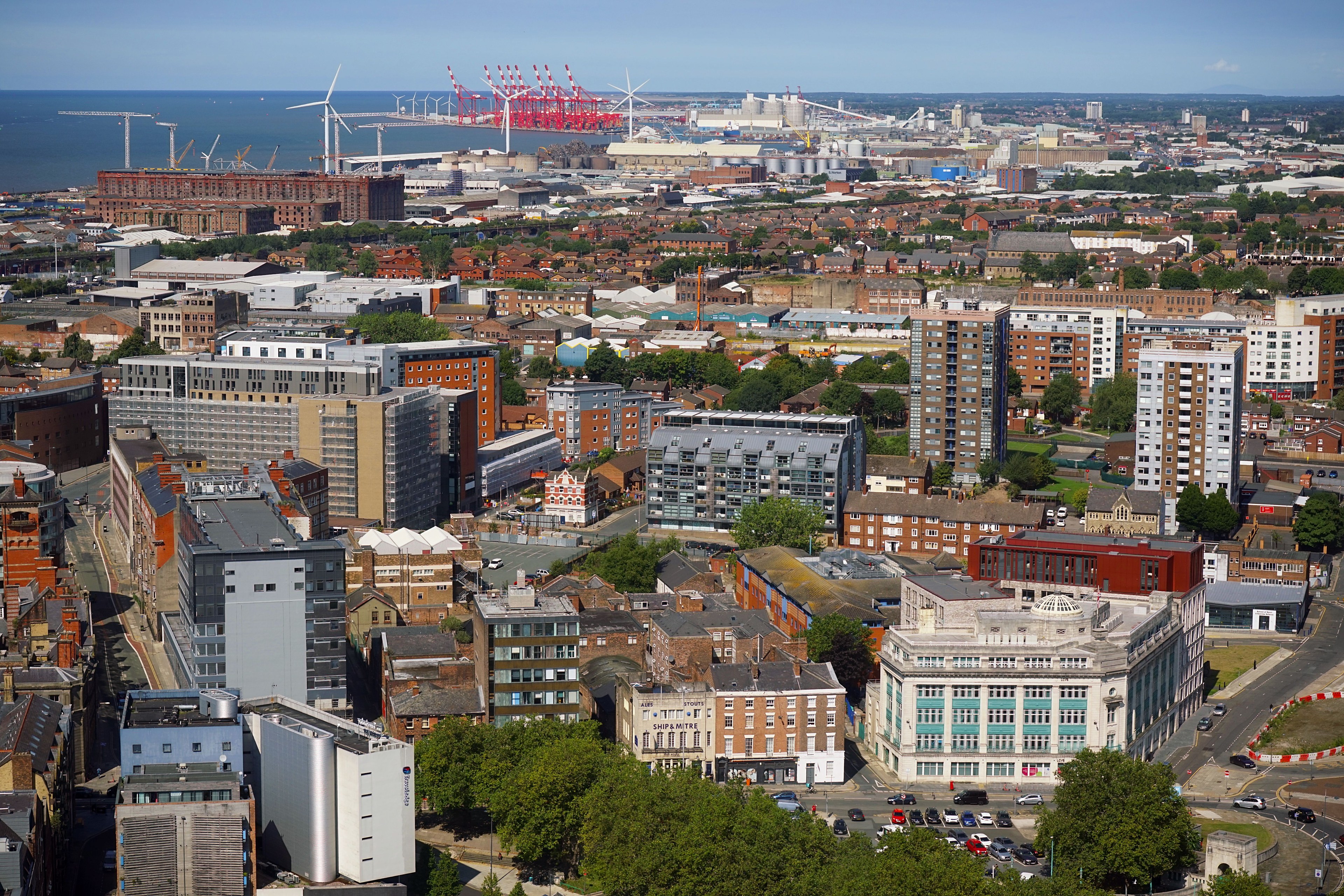 Stunning aerial view of Liverpool showcasing urban architecture and skyline under clear blue skies.